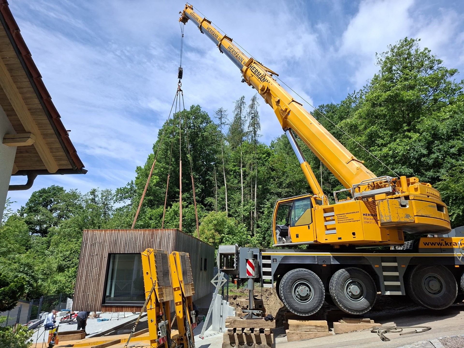 Hermann-Kran hebt ein Gebäudemodul auf einer Baustelle